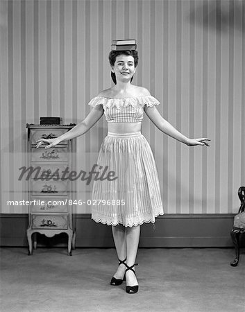 846-02796885em-1940s-1950s-young-woman-in-dress-balancing-books-on-head-stock-photo.jpg